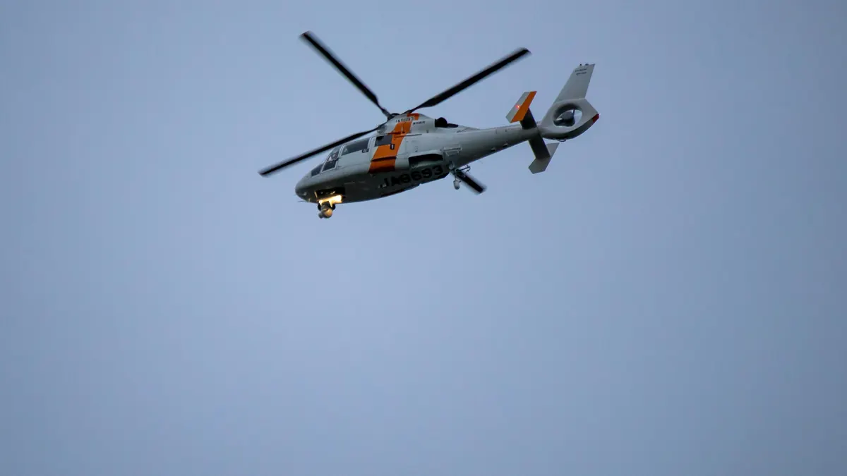 Helicopter flying across a clear blue sky