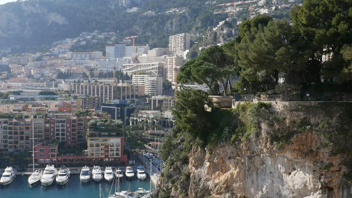 Riviera town and harbour below a rocky headland