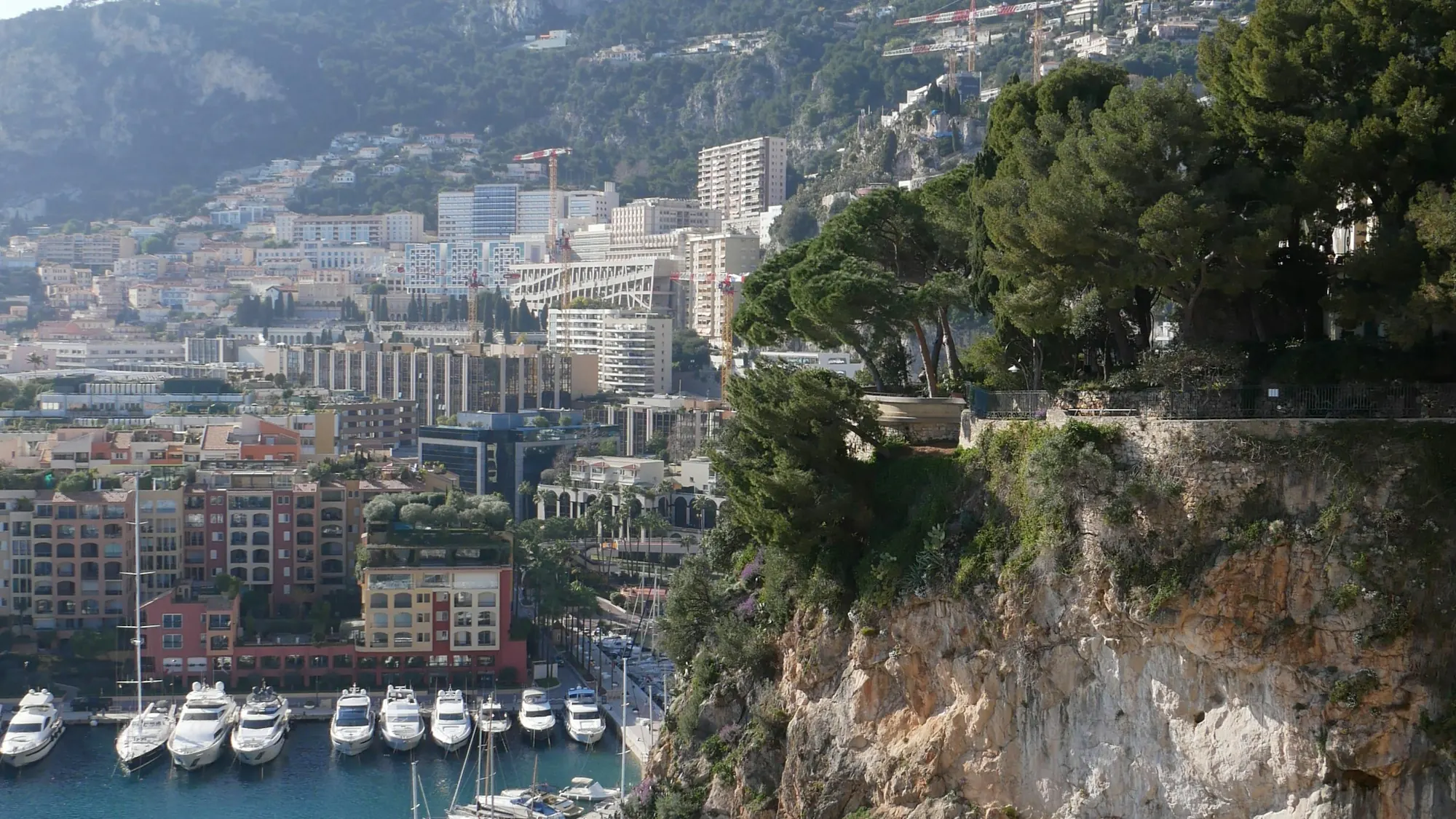 Riviera town and harbour below a rocky headland